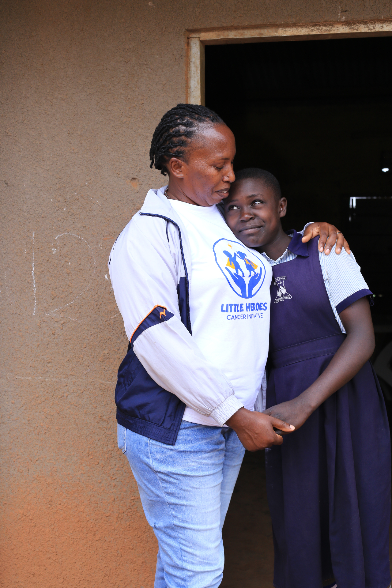 Little Heroes founder standing with a schoolgirl during a community visit